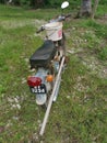 Vintage Motorcycle park outskirt of the plantation carrying long handle Hoe