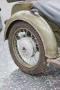 Vintage motorcycle wheel, worn and possibly restored Distinctive hubcap, dim lighting with shadows, diffuse nature of illumination Royalty Free Stock Photo