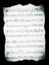 Vintage music sheet with burned edges in the blur. Royalty Free Stock Photo