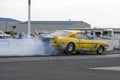 Vintage mustang making smoke show on the track at the starting line