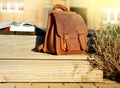 vintage natural leather backpack and books on gray rustic wooden stairs Royalty Free Stock Photo