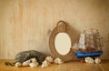 Vintage nautical frame from ropes, wooden boat and natural seashells on wooden table