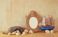 Vintage nautical frame from ropes, wooden boat and natural seashells on wooden table