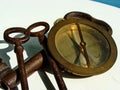 Vintage navy compass and three solid iron, rusted keys. Close up.