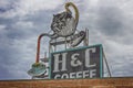 Vintage Neon Coffee Sign under cloudy skies Royalty Free Stock Photo