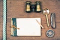 Vintage notebook, compass, binoculars, old pocket knife, pencil, magnifying glass on wooden background Royalty Free Stock Photo