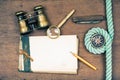 Vintage notebook, compass, binoculars, old pocket knife, pencil, magnifying glass on wooden desk background Royalty Free Stock Photo