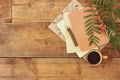 vintage notebook, old paper and wooden pencil next to cup of coffee over wooden table. ready for mockup