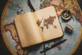 Vintage notebook on old world map with compass, ink jar, and fountain pen Royalty Free Stock Photo