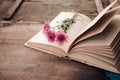 Vintage novel books with bouquet of flowers on old wood background