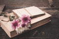 Vintage novel books with bouquet of flowers on old wood background