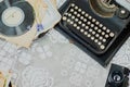 Vintage office desk with typewriter, stack of vinyl and camera on tablecloth