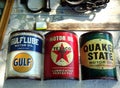 Vintage oil cans lined up at an outdoor flea market