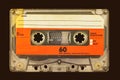 Retro styled image of an old audio compact cassette in front of a dark brown background