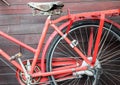 Old red bike on the background of a brown wooden wall Royalty Free Stock Photo