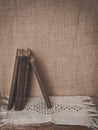 Vintage old book and lace fabric on burlap fabric background Royalty Free Stock Photo