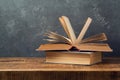 Vintage old books on wooden table over blackboard background. Education Royalty Free Stock Photo