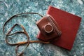 A vintage old camera in a brown leather case lies on a brown stylish photo book Royalty Free Stock Photo