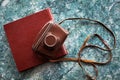 A vintage old camera in a brown leather case lies on a brown stylish photo book Royalty Free Stock Photo