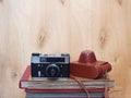 Vintage old film photo-camera with leather case on wooden background Royalty Free Stock Photo