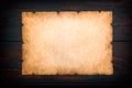 Vintage old grunge background texture paper scroll on dark wooden background. Brown burnt paper background. Frame mockup Royalty Free Stock Photo