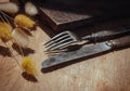 Vintage old metal knife with fork and Dried rabbit tail grass flowers on old rustic wooden table. Eating concept, Copy space