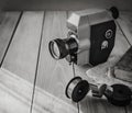 Vintage old movie camera and film reels on a wooden table, old book, clothl. Retro photo. Copy space.