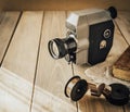 Vintage old movie camera on a wooden table, old book, clothl. Retro photo. Copy space. Royalty Free Stock Photo