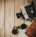 Vintage old movie camera on a wooden table, old book, clothl. Retro photo. Copy space. Top view. Royalty Free Stock Photo