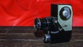 Vintage old movie camera on the wooden table on the red background Royalty Free Stock Photo