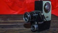 Vintage old movie camera on the wooden table on the red background. Space for text Royalty Free Stock Photo