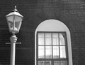 Vintage old street lamp on the background of a brick wall of an old building and a white window lit by the sun Royalty Free Stock Photo