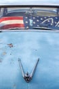 Vintage old timer car with hood ornament and american flag covering the front seat