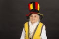 Vintage old woman wearing cylinder and a yellow vest