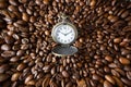 Vintage opened pocket watch among coffee beans. Funnel effect on sides of image. Morning coffee energy, 10 o`clock. Royalty Free Stock Photo
