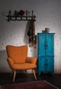 Vintage orange armchair, blue cupboard, wall hanger and black scarf