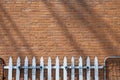 Vintage orange brick wall texture background with shadows and rustic fence Royalty Free Stock Photo