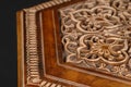 Vintage oriental wooden table with the artistic carving on a black background, Uzbekistan, close-up