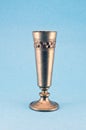 Vintage ornamental metal goblet cup on blue background