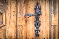 Vintage and ornate, iron leaf shaped doorhandle with defocused iron ornaments Royalty Free Stock Photo