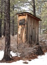 Vintage Outhouse in Forest Snow