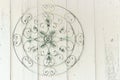 Round ornate metal medallion hanging on wooden wall