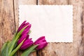 Vintage paper card with tulips on wood background Royalty Free Stock Photo