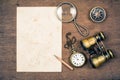 Vintage paper for map, old binoculars, compass, pocket watch,pencil, rope, magnifying glass on wooden background