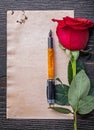 Vintage paper red expanded rose fountain pen on wooden board