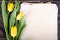 Vintage paper, pencils and yellow tulips on wooden background. Free space for your text. Royalty Free Stock Photo