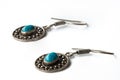 Silver earrings with turquoise stones on white