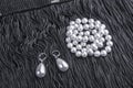 Vintage pearl jewelry on little black dress. Gatsby or Chicago fashion look. Luxury white necklace and earrings. Getting ready for