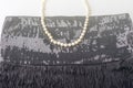 Vintage pearl jewelry on little black dress. Gatsby or Chicago fashion look. Luxury white necklace. Getting ready for party.