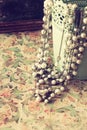 Vintage pearl necklace over floral pattern background. retro filter